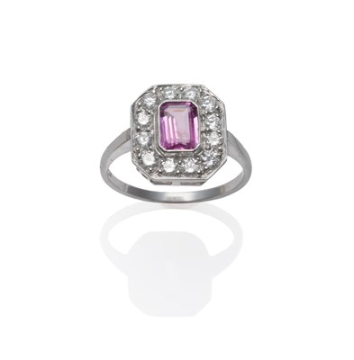 Lot 202 - A Pink Sapphire and Diamond Cluster Ring, an emerald-cut pink sapphire within a border of round...