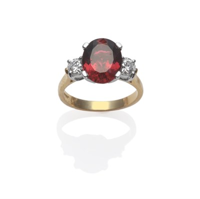 Lot 203 - An 18 Carat Gold Red Tourmaline and Diamond Three Stone Ring, an oval cut tourmaline between...