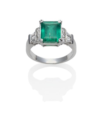 Lot 205 - An 18 Carat White Gold Emerald and Diamond Ring, an emerald-cut emerald in a white claw setting, to