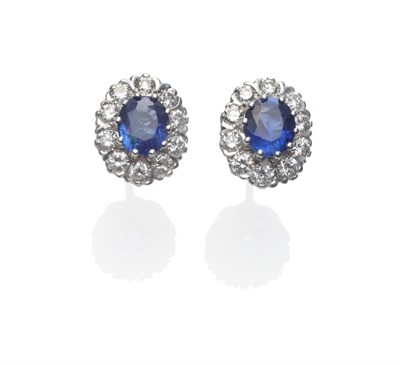 Lot 209 - A Pair of 18 Carat White Gold Sapphire and Diamond Cluster Earrings, each with an oval mixed...