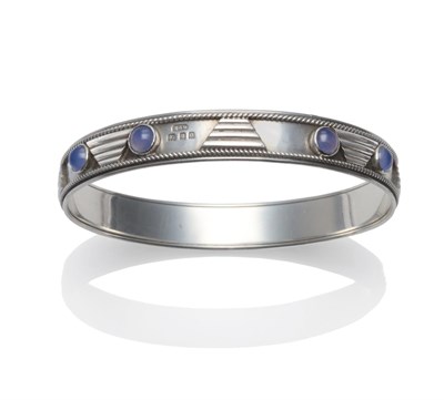 Lot 225 - A Silver Bangle, by H G Murphy, set with blue cabochon chalcedony with geometric panels, and...