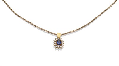 Lot 269 - A Sapphire and Diamond Cluster Pendant, an oval mixed cut sapphire within a border of round...