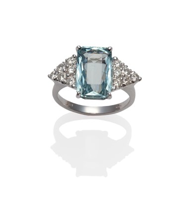 Lot 272 - An 18 Carat White Gold Aquamarine and Diamond Ring, a scissor cut aquamarine with a cluster of...