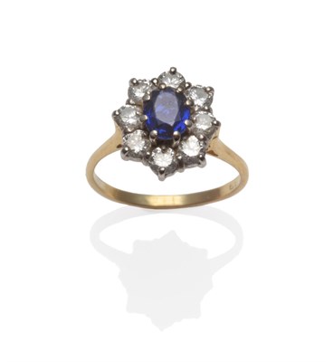 Lot 274 - An 18 Carat Gold Sapphire and Diamond Cluster Ring, the oval cut sapphire within a border of...