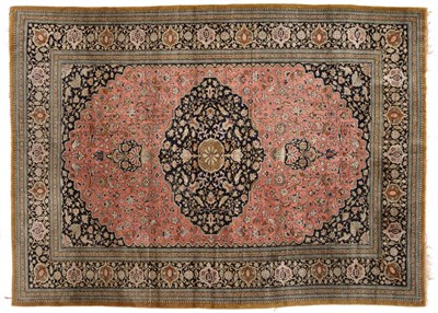 Lot 849 - Ghom Silk Rug Central Persia The coral field of floral vines around a cusped indigo pole...