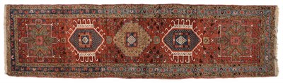 Lot 855 - Narrow Heriz Runner Persian Azerbaijan The madder field with a column of latch hook stepped...