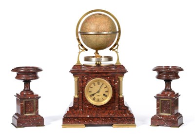 Lot 909 - A Rare and Unusual Red Marble Calendar Terrestrial Globe Striking Mantel Clock with Garniture,...