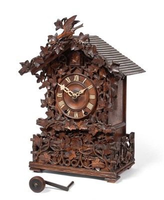 Lot 931 - A Black Forrest Striking Cuckoo Table Clock, circa 1880, elaborately carved chalet form case,...