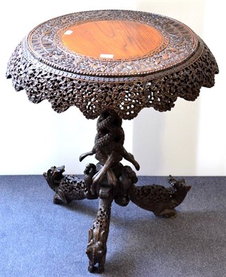 Lot 956 - A Late 19th Century Bombay Carved Hardwood Tripod Table, richly carved with a foliate shaped apron