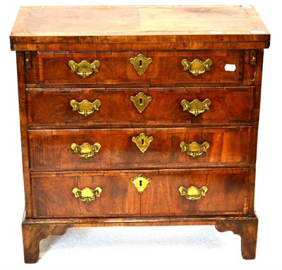 Lot 988 - A Walnut and Featherbanded Bachelor's Chest, the quarter-veneered hinged lid above pull-out...