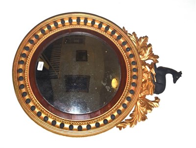 Lot 1092 - A Regency Ebonised and Gilt Convex Mirror, early 19th century, with mercury mirror plate,...