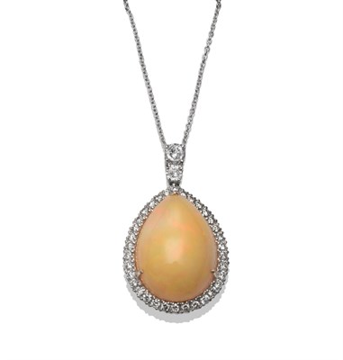 Lot 147 - An 18 Carat White Gold Opal and Diamond Pendant, a pear shaped cabochon opal within a border of...