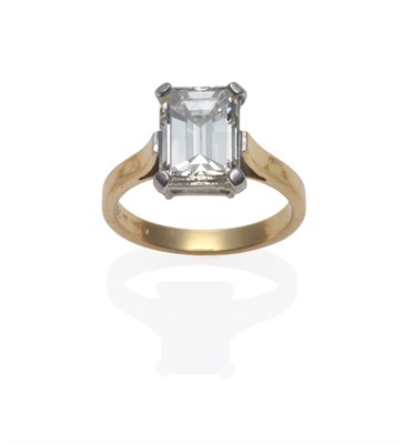 Lot 194 - A Diamond Solitaire Ring, the baguette cut diamond in a white four claw setting, to a yellow...