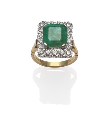 Lot 265 - An Emerald and Diamond Cluster Ring, an emerald-cut emerald in a white claw setting, within a...