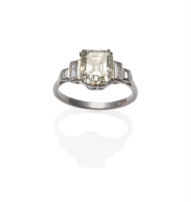 Lot 296 - A Diamond Ring, circa 1920, the emerald-cut central diamond in a white split claw setting, with...