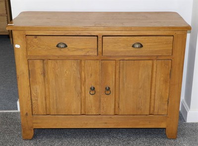 Lot 3043 - An Oak Sideboard, modern, with two drawers above cupboard doors enclosing a shelf, 123cm by 50cm by