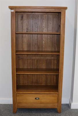 Lot 3044 - An Oak Free-Standing Bookcase, modern, with three fixed shelves above a long drawer, 90cm by...