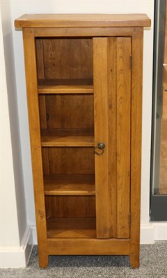 Lot 3045 - An Oak CD Cabinet, modern, with three fixed shelves flanked by a cupboard door fitted with...