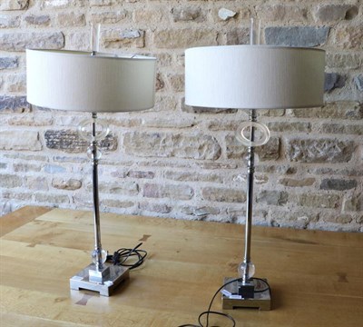 Lot 3069 - A Pair of Chrome and Plastic Art Deco Style Table Lamps, modern, with narrow cream shades enclosing