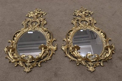 Lot 3077 - A Pair of Gilt Two-Branch Girandoles, modern, with oval mirror plates and scrolled frames...