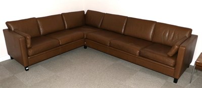 Lot 3168 - A 1970s Danish Design Brown Leather Corner Sofa, in three sections, with fifteen cushions and...