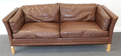Lot 3169 - A 1970s Danish Design Two-Seater Sofa, upholstered in brown leather with cushions and rounded arms