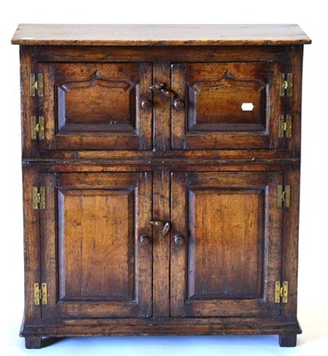 Lot 3011 - A Reproduction Oak Side Cabinet, with four fielded cupboard doors with brass H shape hinges,...