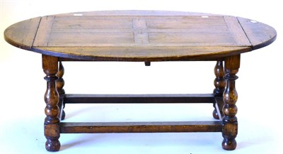 Lot 3012 - A Reproduction Oak Dropleaf Coffee Table, the rectangular top with four oval drop leaves, raised on