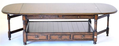 Lot 3021 - A Reproduction Oak Dropleaf Coffee Table, with two rounded drop flaps above pull-out slides, raised
