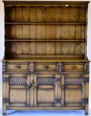 Lot 3024 - A Reproduction Oak Dresser and Rack, with two fixed shelves above three frieze drawers, with...