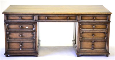 Lot 3025 - A Reproduction Oak Double Pedestal Desk, 20th century, with three frieze drawers above two...