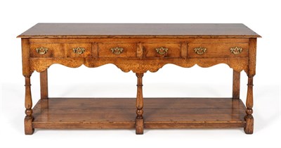 Lot 3029 - A Reproduction Oak Dresser Base, with four frieze drawers above an arched apron, raised on baluster