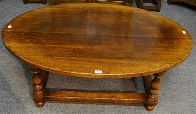 Lot 3035 - A Reproduction Oak Coffee Table, of oval form, raised on turned baluster legs joined by an H...