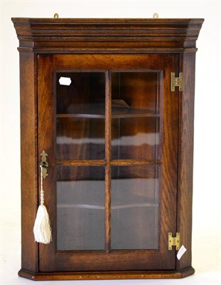Lot 3036 - A Reproduction Oak Hanging Corner Cupboard, of recent date, with glazed door enclosing two...