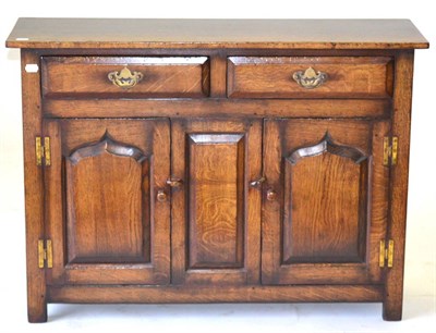 Lot 3042 - A Titchmarsh and Goodwin Oak Cupboard, with two drawers above two fielded cupboard doors, raised on