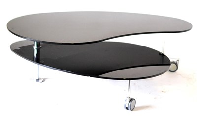 Lot 3045 - A Black Glass Coffee Table, of recent date, of kidney shape form raised on polished tubular...