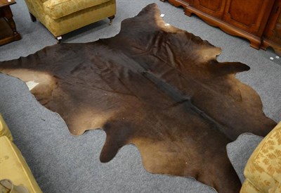 Lot 3142 - A Large Brown and Black cowhide floor rug of recent date, 210cm width by 224cm long