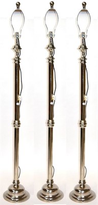 Lot 3149 - A Set of Three Chromed Standard Lamps, of recent date, with cream shades, column supports and...