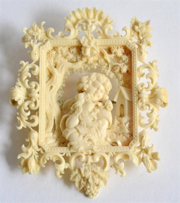 Lot 797 - A 19th Century Dieppe Ivory Carved Brooch, in the form of a cherub seated in a landscape...