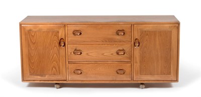 Lot 3156 - An Ercol Light Elm Low Sideboard, with three drawers and two cupboard doors, raised on castors,...