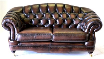 Lot 3208 - A Chesterfield Style Two-Seater Sofa, labelled Thomas Lloyd, upholstered in buttoned brown...