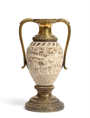 Lot 813 - An Indian Carved Ivory and Gilt Metal Mounted Two-Handled Pedestal Vase, circa 1900, the ovoid body