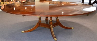 Lot 1008 - A Regency Style Mahogany Extending Circular Dining Table, of recent date, the crossbanded top...