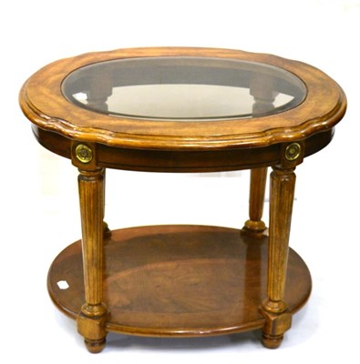 Lot 1021 - A Walnut Two-Tier Oval Lamp Table, with bevelled glass plate above reeded tapering legs joined by a