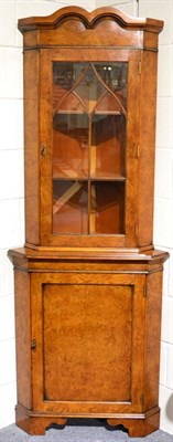 Lot 1028 - A Reproduction Burr Walnut Corner Cabinet, with a moulded cornice above an astragal glazed...