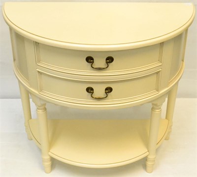 Lot 1041 - A Cream Painted D Shaped Two Drawer Chest of recent date, raised on turned legs adjoined by a shelf