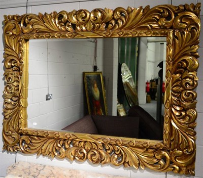 Lot 1090 - A Gilt Composition Mirror, with a rectangular bevel glass plate within acanthus leaf decorated...