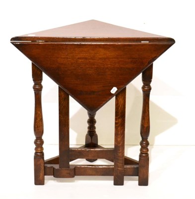 Lot 1117 - A Reproduction Oak Dropleaf Corner Table of recent date, with triangular drop leaf above a pivoting