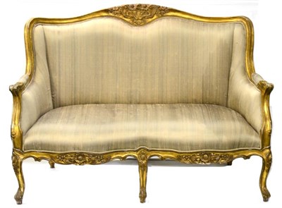 Lot 1171 - A Gilt Composition Two-Seater Sofa in the Louis XVI style upholstered in green watered silk,...