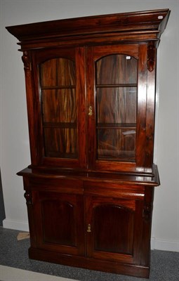 Lot 1015 - A Reproduction Hardwood Victorian Style Bookcase, the bold pediment above arched glazed doors...